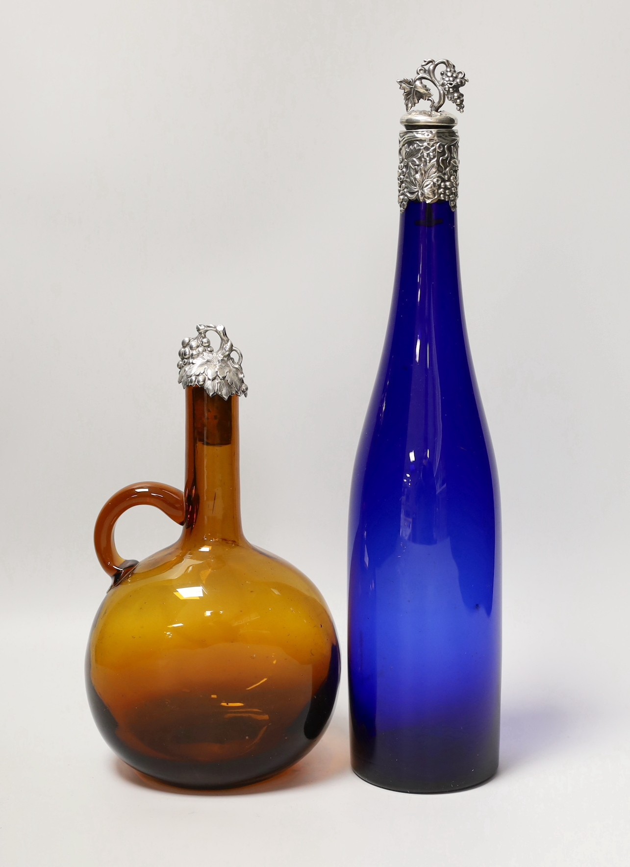 A blue glass hock bottle with George IV silver stopper and an amber glass spirit flask with William IV silver stopper. Tallest 35cm